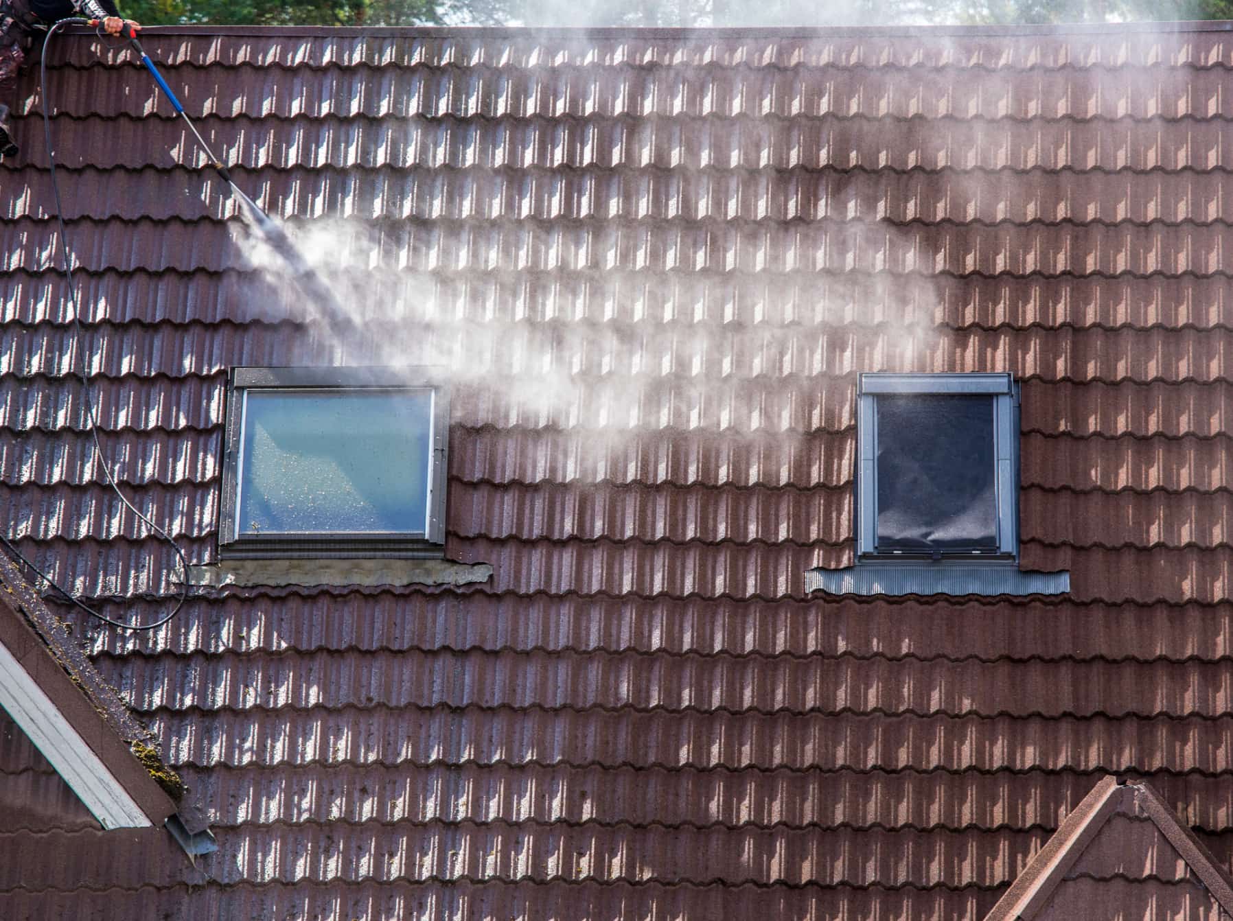 This is a photo of a roof being cleaned using a pressure washer.