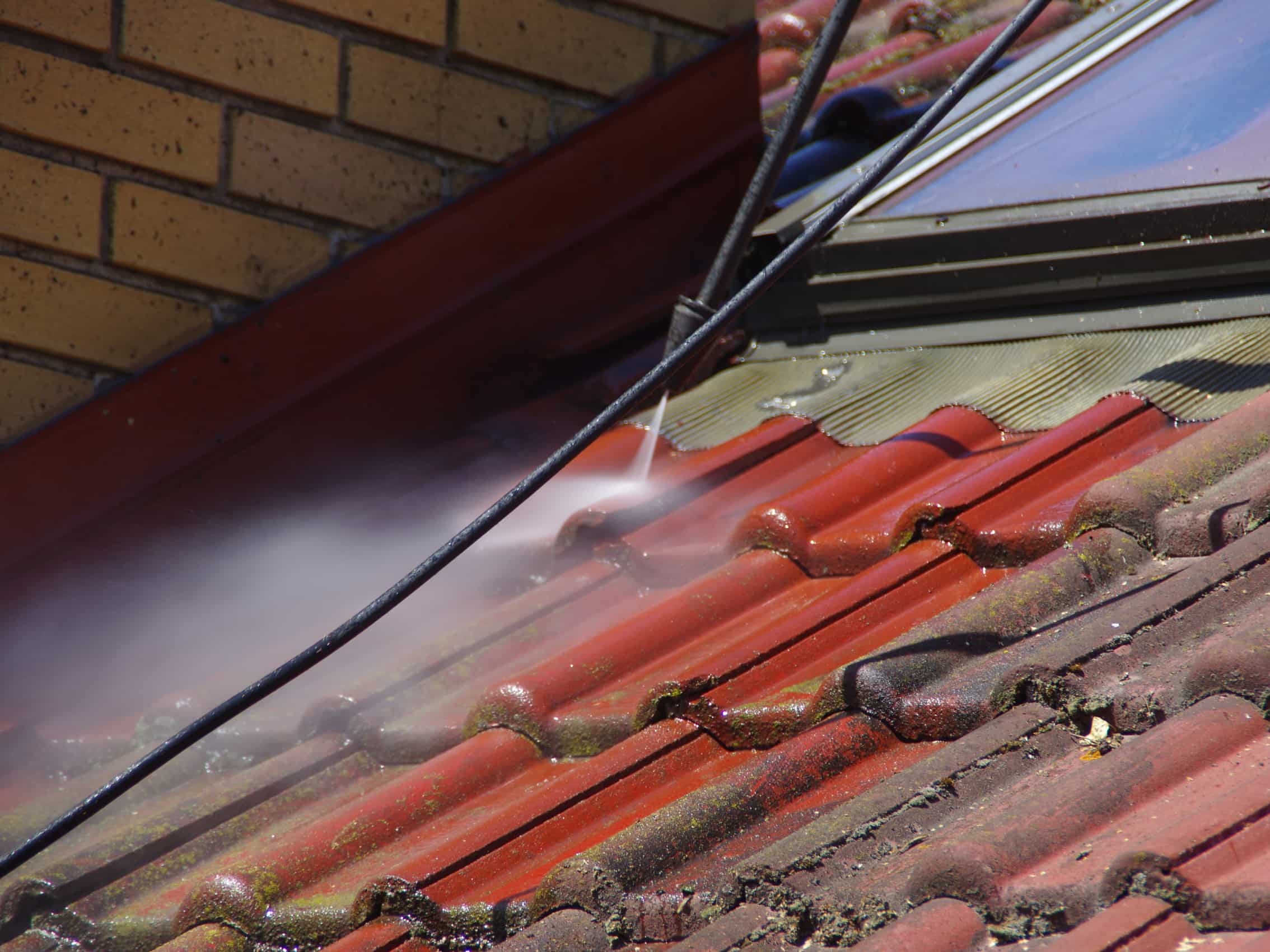 This is a photo of a roof being cleaned using a pressure washer.